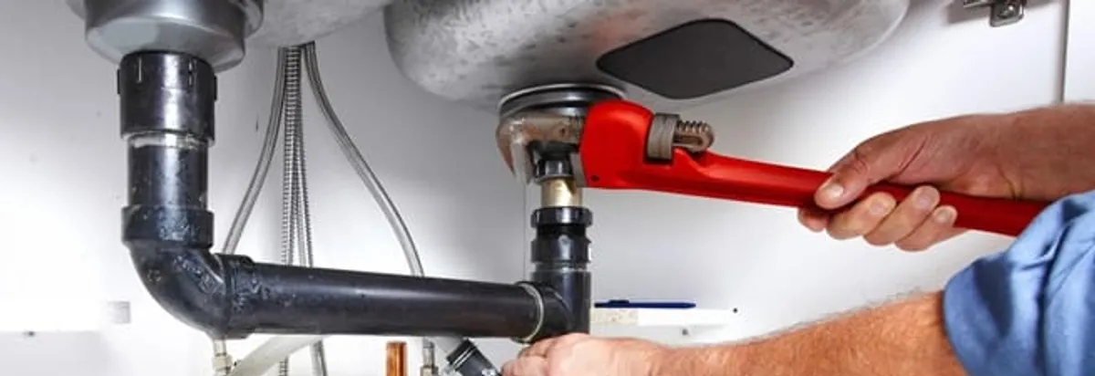 Garbage disposal repair technician tightening the sink drain and disposal connection in Lincoln, NE