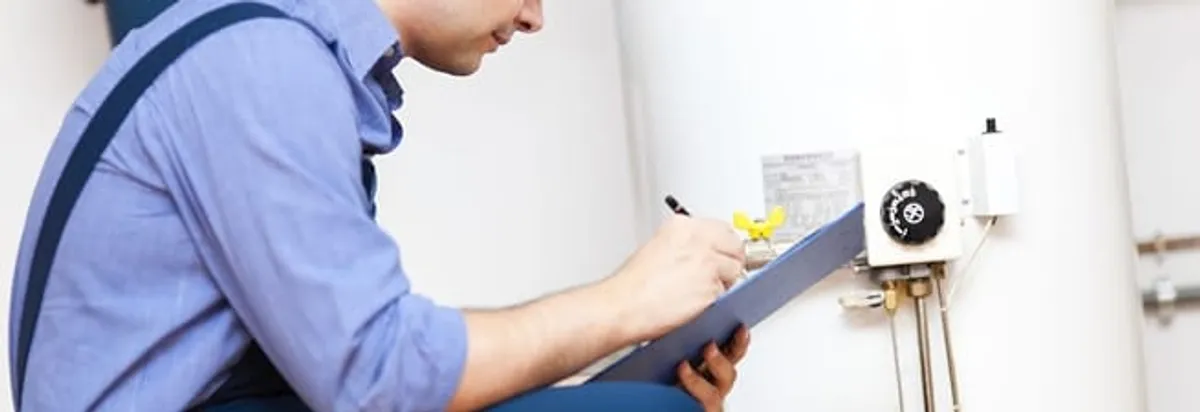 Water heater repair technician inspecting the unit and recording service notes in Lincoln, NE